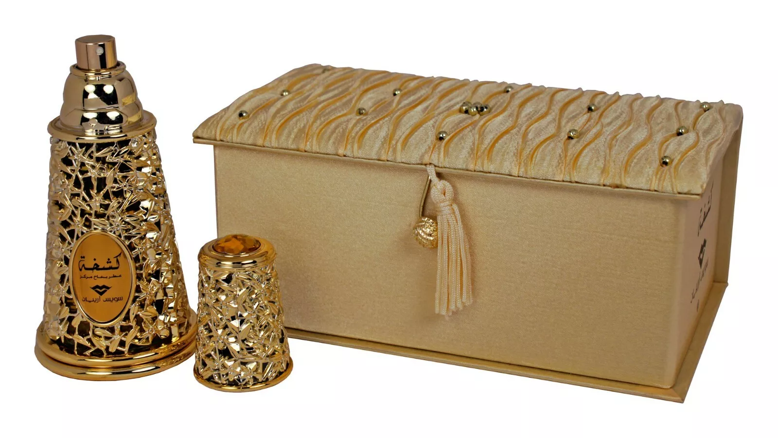 Conjunto dourado com frasco de spray, pequeno objeto decorativo e uma caixa com tampa texturada.