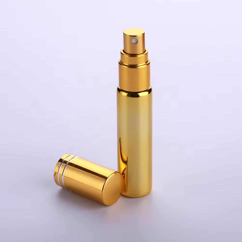 Frasco de spray dourado com tampa ao lado em fundo branco