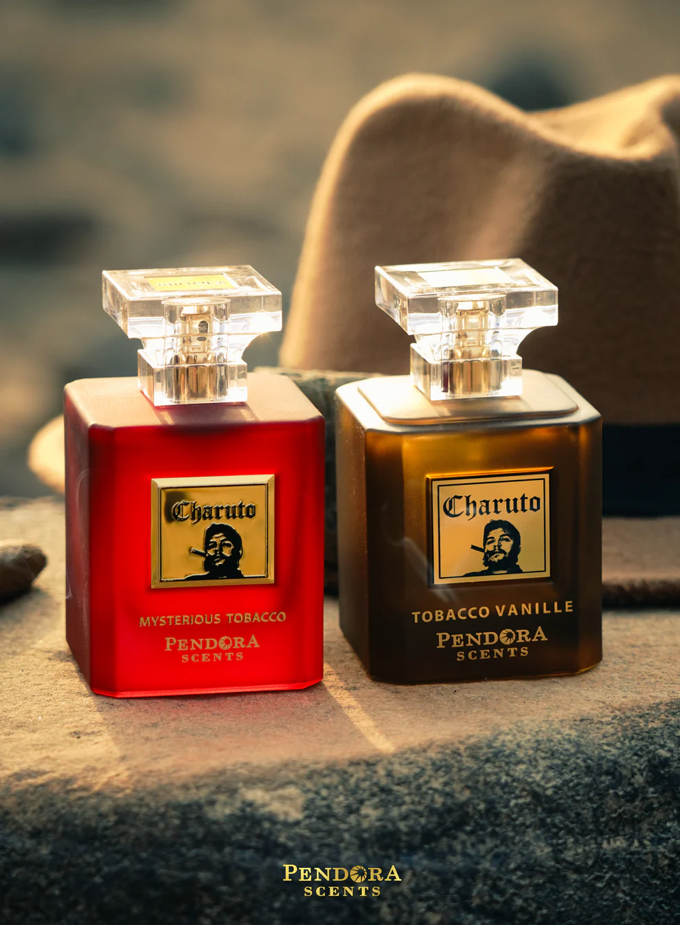 Frascos de perfume Charuto Mysterious Tobacco e Tobacco Vanille da Pendora Scents sobre pedra com chapéu castanho ao fundo