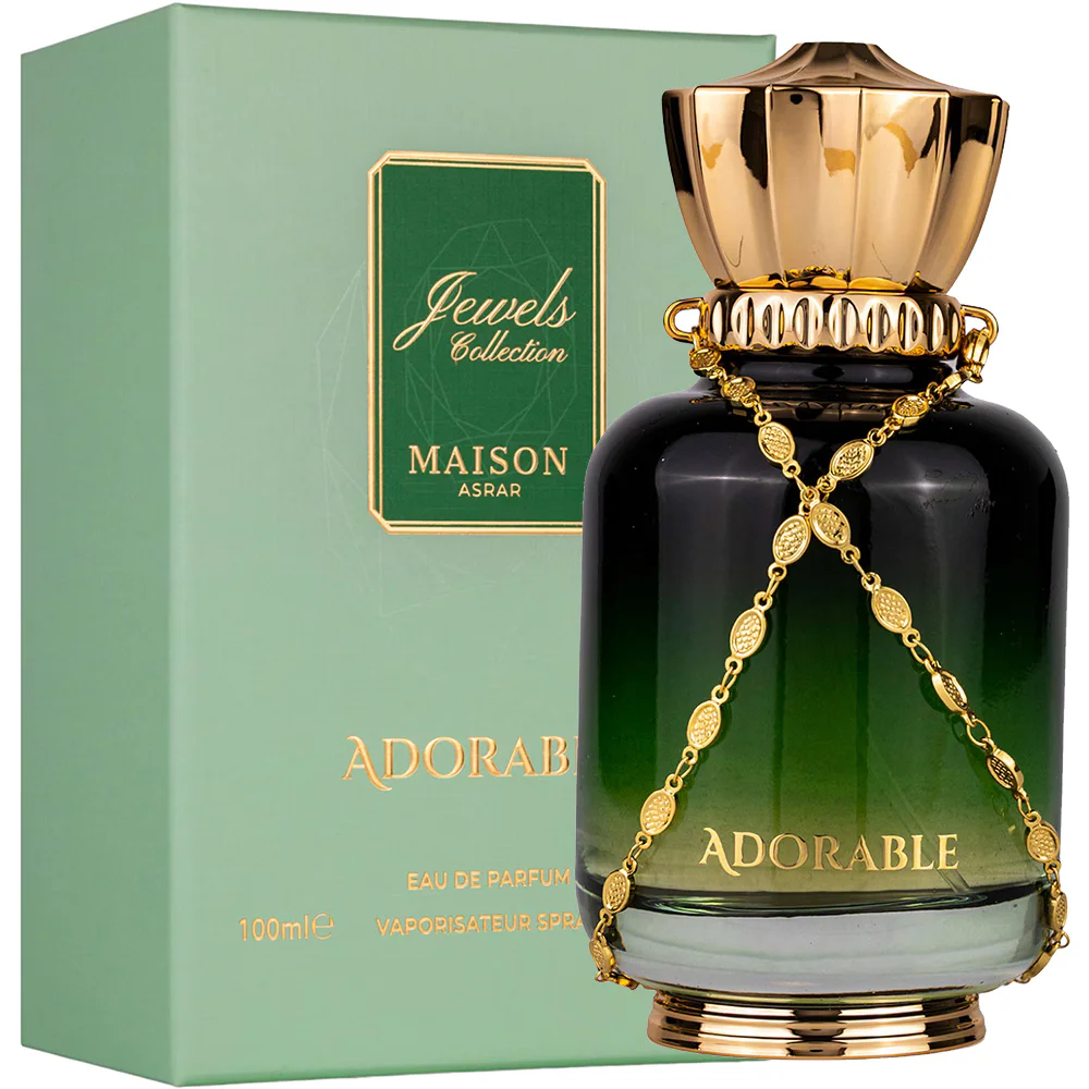 Frasco de perfume verde escuro com tampa e corrente dourada junto a caixa verde clara