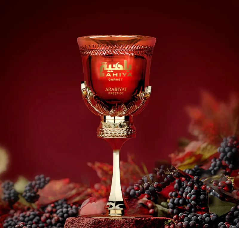 Frasco de perfume vermelho com detalhes dourados e frutos escuros