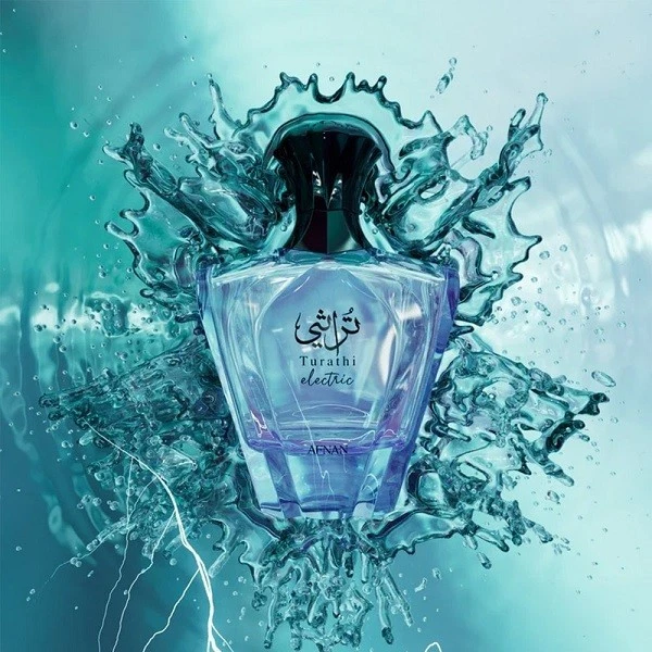 Frasco de perfume azul com tampa preta rodeado por água