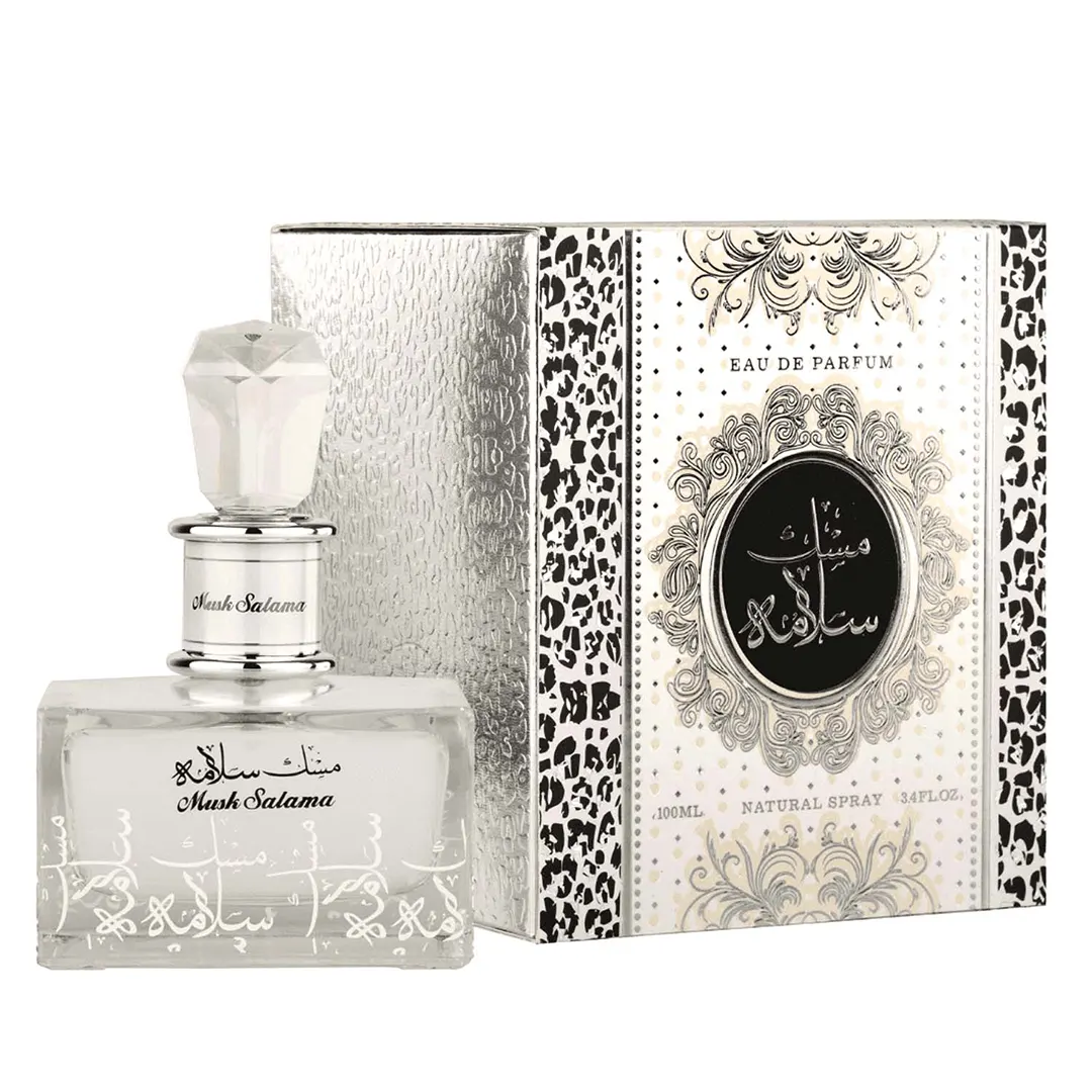 Frasco de perfume transparente com tampa branca ao lado de caixa branca decorada