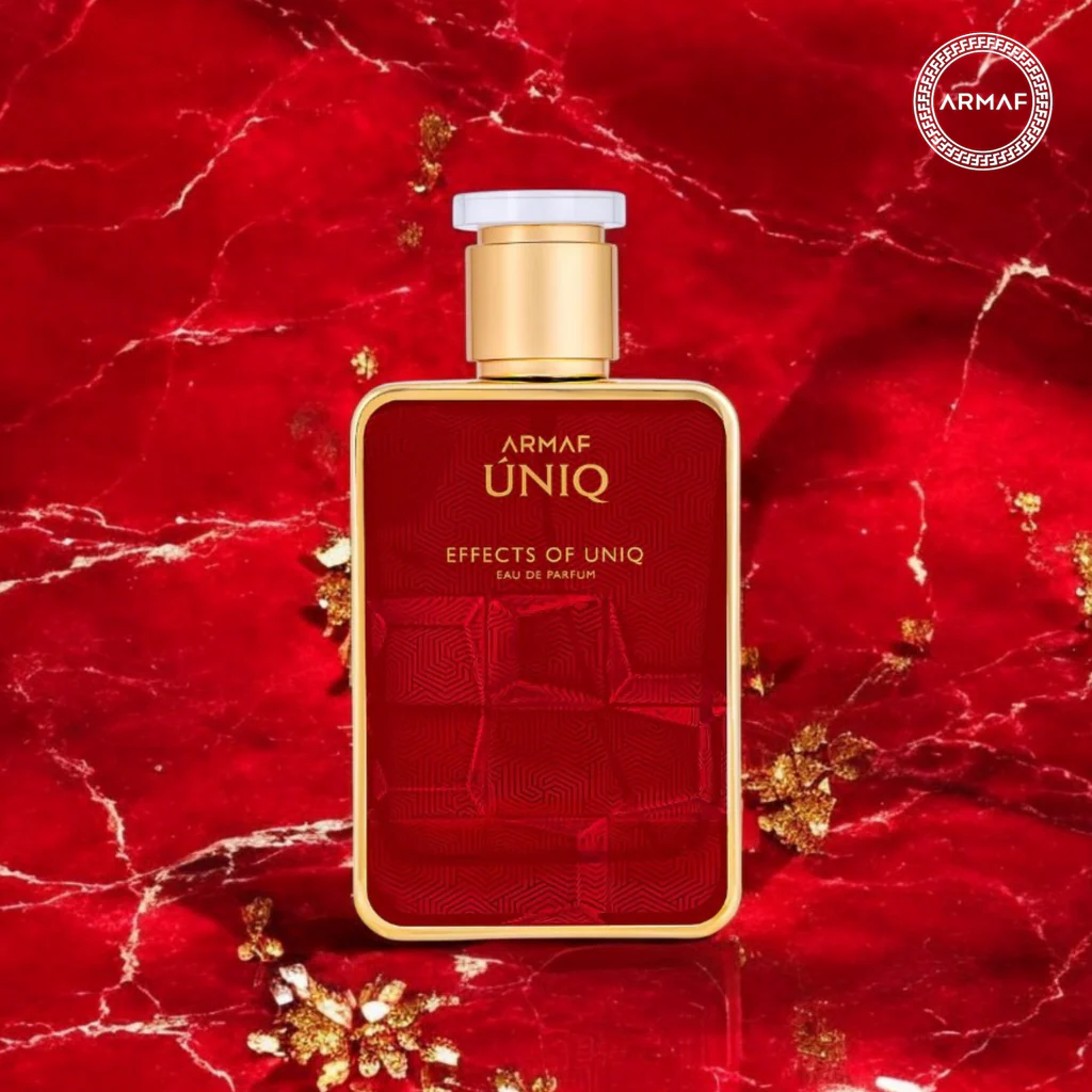 Frasco de perfume Armaf ÚNIQ vermelho e dourado sobre fundo vermelho marmoreado