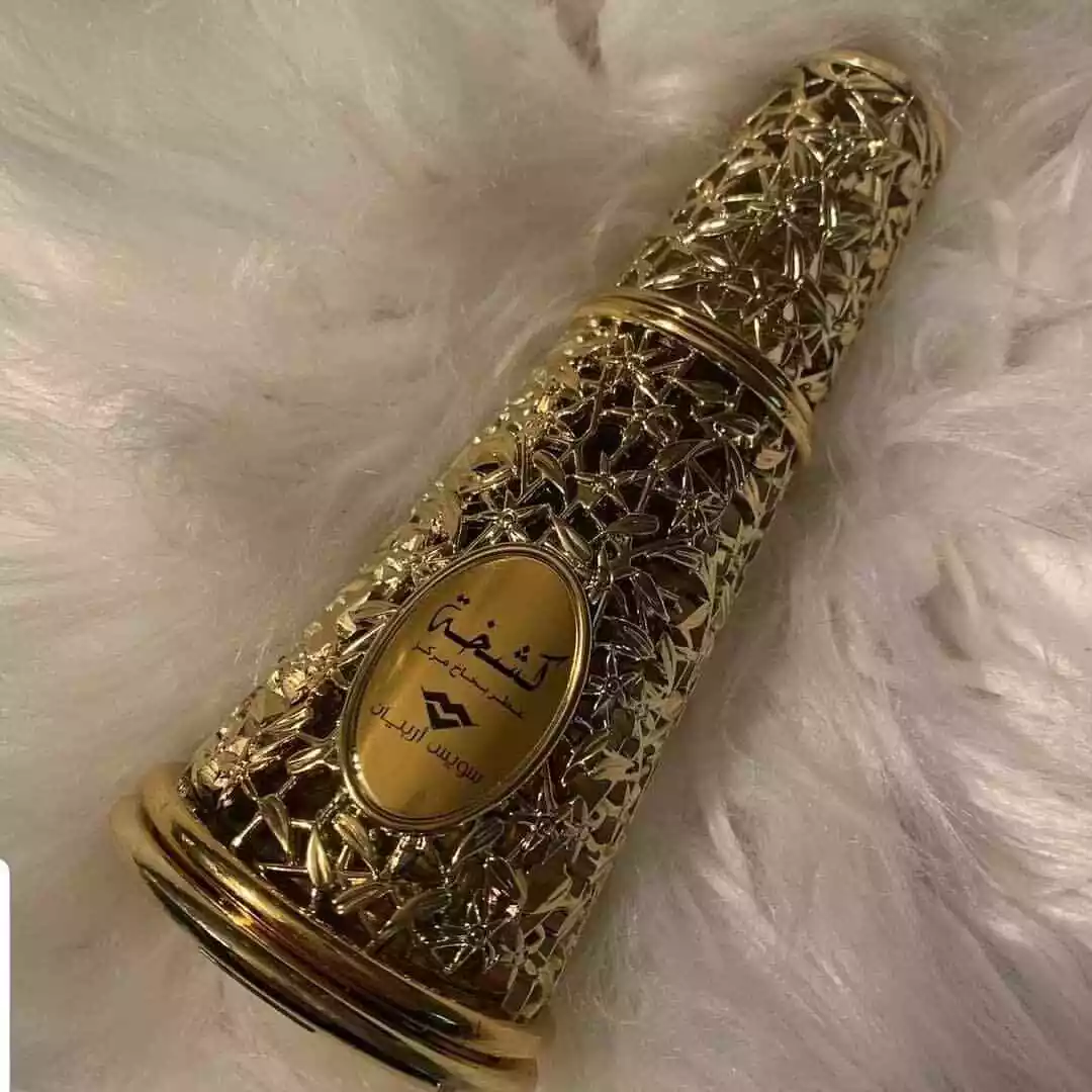 Frasco dourado decorativo de perfume sobre fundo branco macio