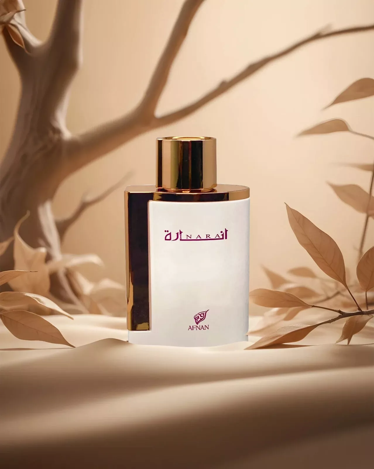 Frasco de perfume branco com tampa dourada em ambiente com folhas secas e galhos