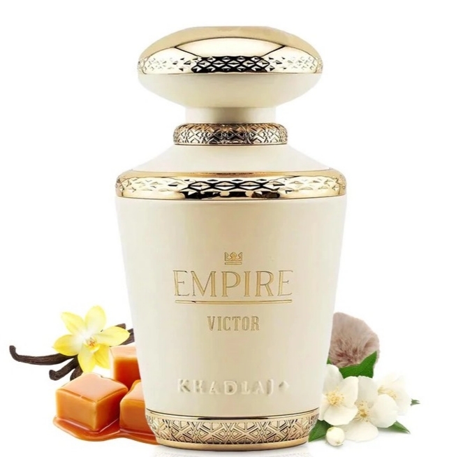 Frasco creme e dourado de perfume Empire Victor Khadlaj com flores e caramelos ao redor