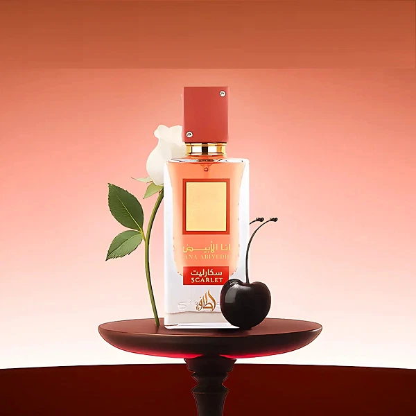 Frasco de perfume vermelho com flor branca e cereja preta sobre pedestal vermelhão
