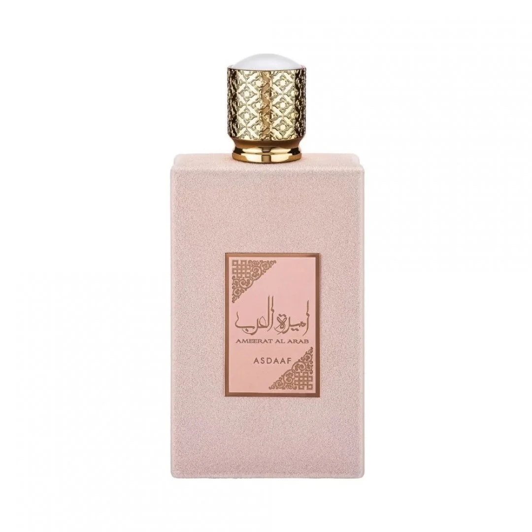 Frasco de perfume rosa com tampa dourada texturizada e etiqueta com texto árabe