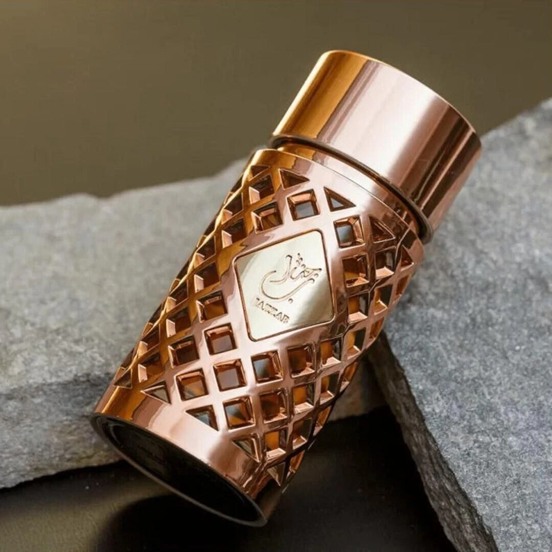 Frasco de perfume dourado com padrão geométrico em pedras