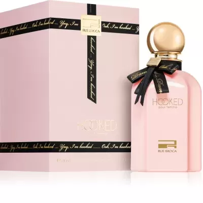 Frasco de perfume rosa e caixa rosa com texto dourado