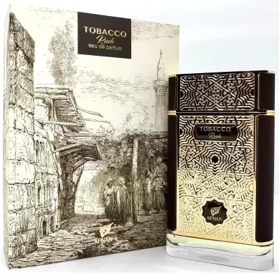 Frasco do perfume TOBACCO RICH em dourado com padrão geométrico e caixa com ilustração de rua antiga