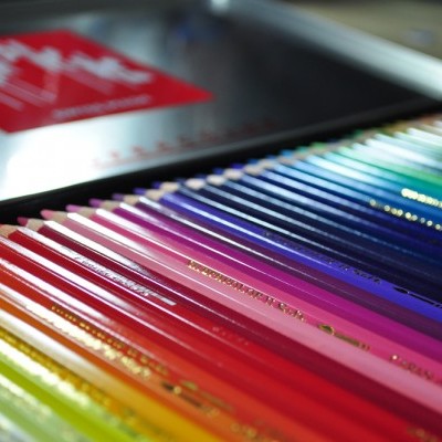 Lápis de cor organizados em caixa metálica com fundo desfocado