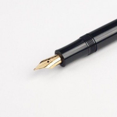 Caneta preta com ponta dourada e fundo branco