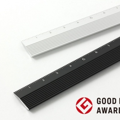 Duas réguas metálicas, uma branca e outra preta, com marcações em cm, em fundo branco e texto GOOD DESIGN AWARD 2013.