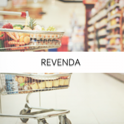 Carrinho de compras cheio numa loja com iluminação e prateleiras ao fundo.