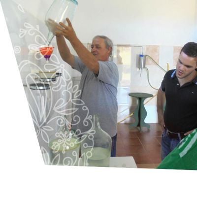 Frasco de vidro transparente com funil de plástico e dois homens numa sala simples