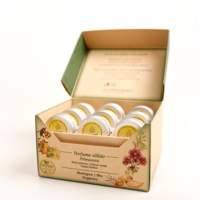 Caixa de cartão aberta com doze frascos pequenos de perfume sólido Primavera em rótulos amarelos e decoração floral.