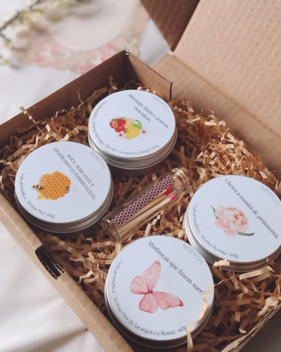 Conjunto de velas aromáticas em latas com tampa branca, desenhos e caixa de cartão