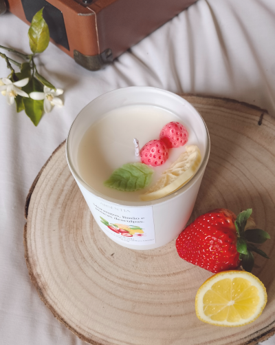Vela branca decorada com frutas falsas e base de madeira