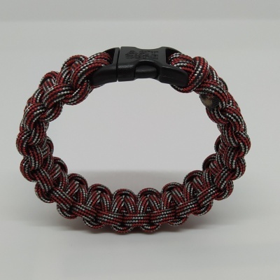 Pulseira têxtil trançada em preto, vermelho e branco com fecho de plástico preto