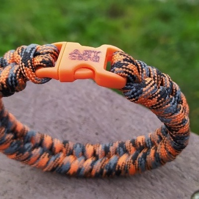 Pulseira trançada camuflada laranja, preto e cinzento com fecho de plástico laranja