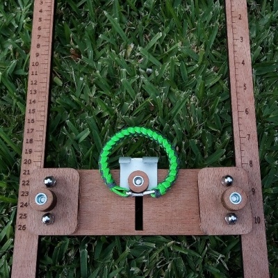 moldura de madeira ART cord com pulseira verde e ajustes metálicos sobre relva