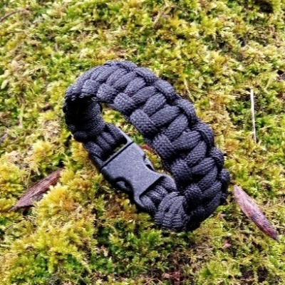 Pulseira trançada preta com fivela em plástico no musgo