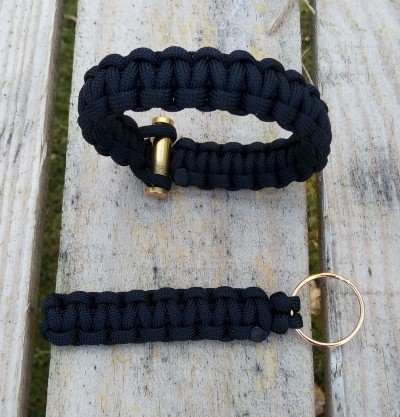 Pulseira e porta-chaves de corda preta trançada sobre madeira clara