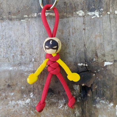 Porta-chaves boneco cordas vermelhas braços amarelos cabeça madeira máscara preta