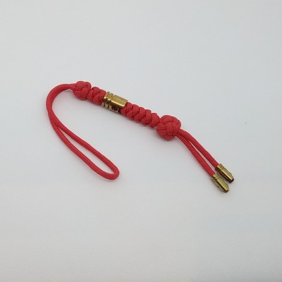 Pulseira vermelha trançada com detalhes metálicos dourados