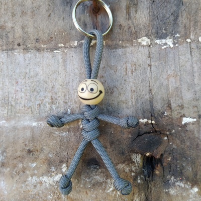 Chaveiro figura humana de corda cinzenta com cabeça de madeira sorridente