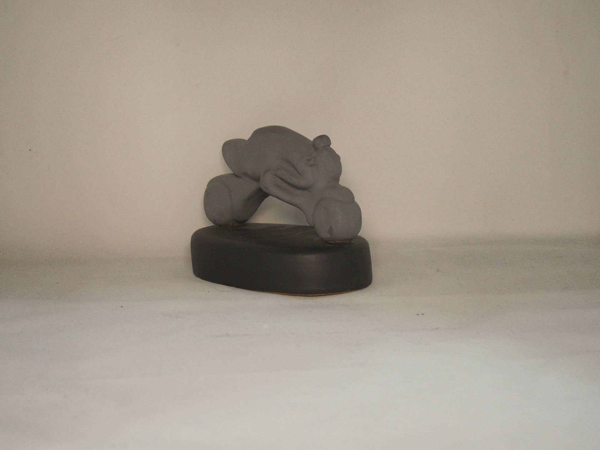 Figura cinzenta de personagem animado sobre base preta