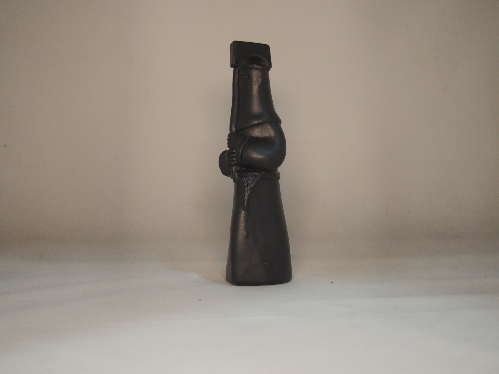 Estatueta decorativa em madeira escura com figura humana estilizada