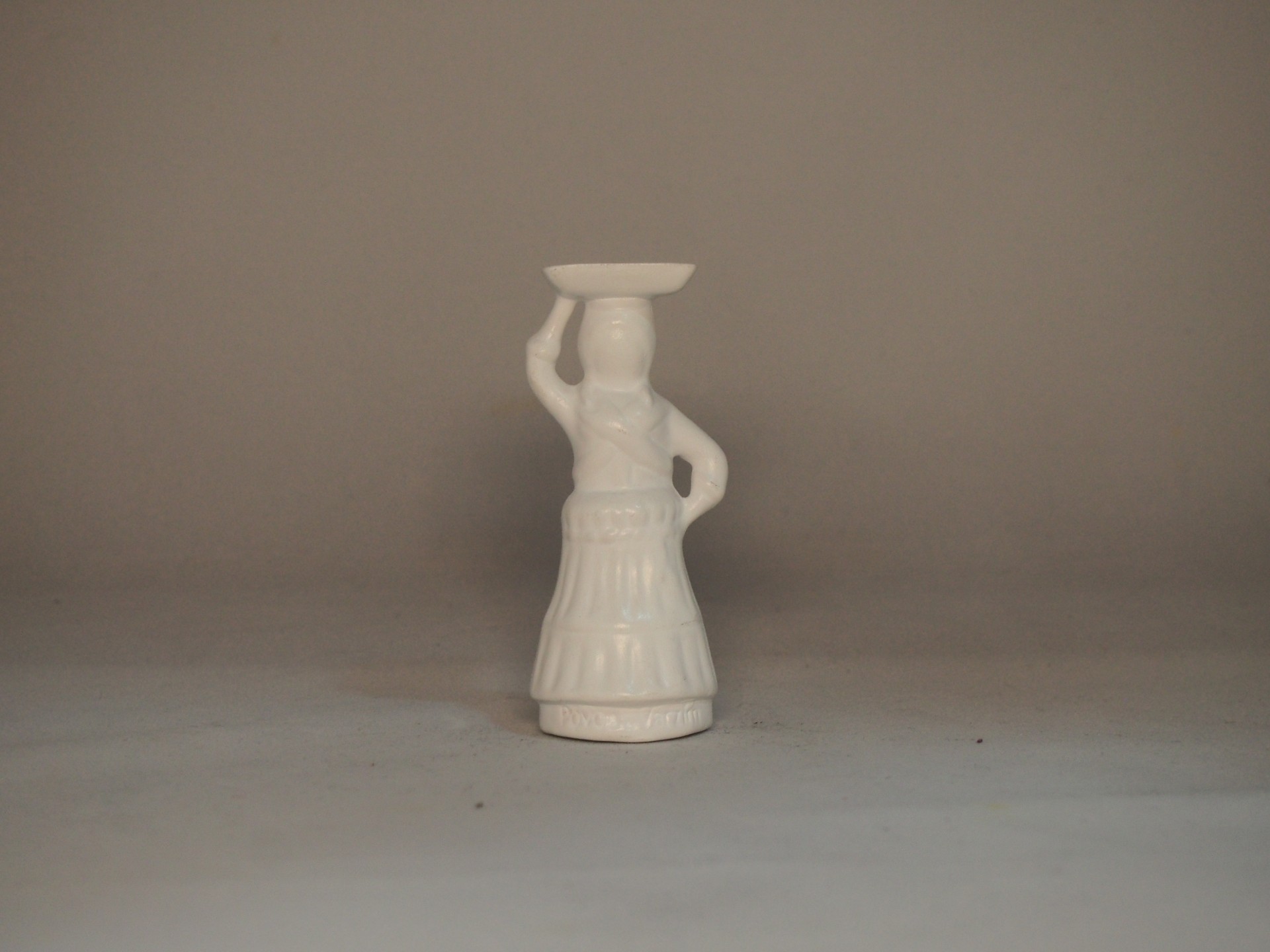 Figurine em cerâmica branca de mulher com prato na cabeça