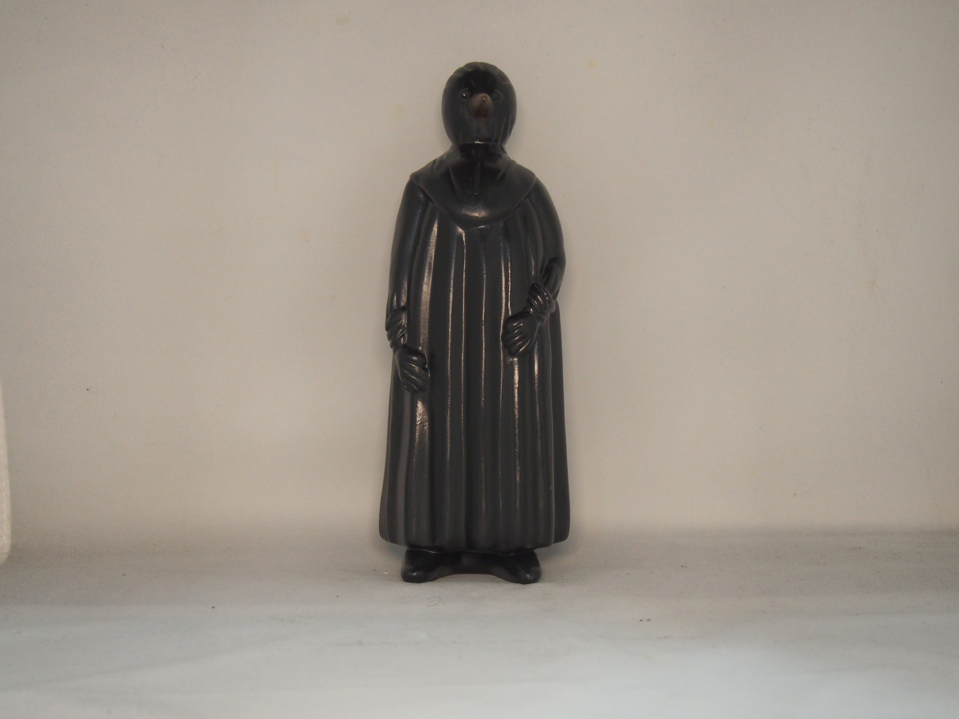 Estátua de personagem com manto preto