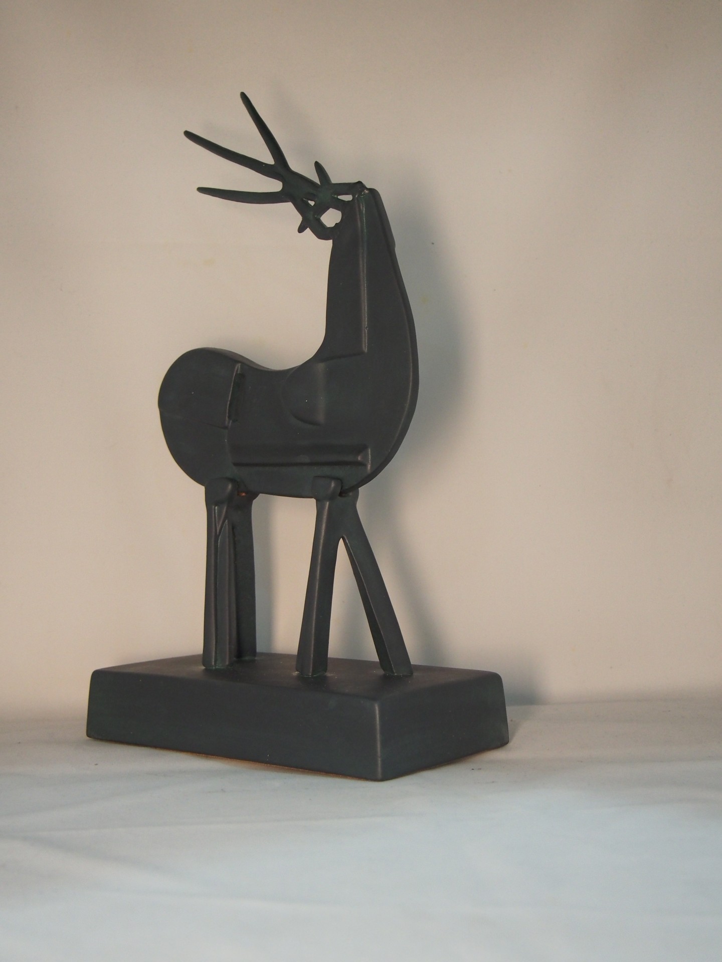 Escultura preta abstrata de veado em metal com base retangular