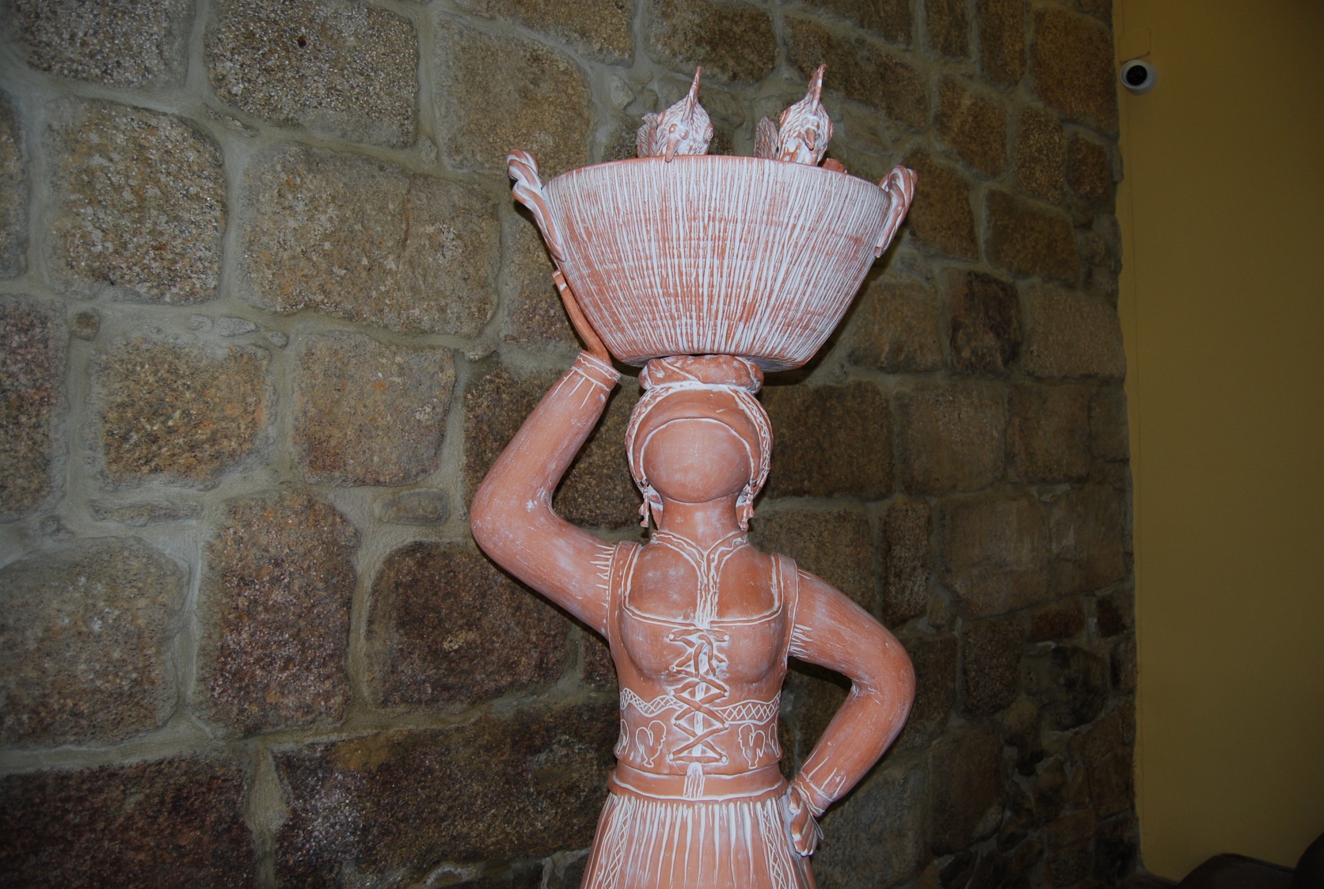 Escultura em terracota de figura humana com cesta de frutas na cabeça
