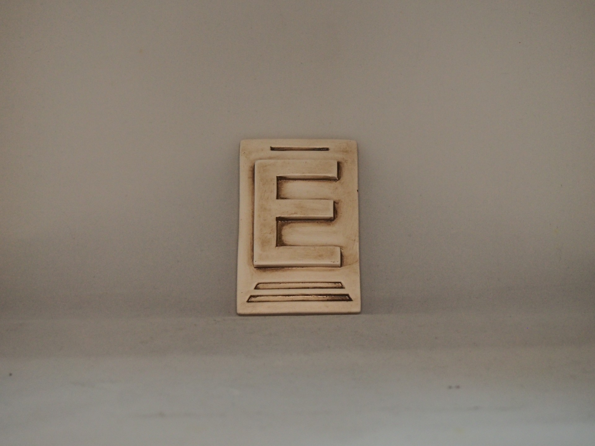 Peça decorativa em madeira clara com design geométrico recortado