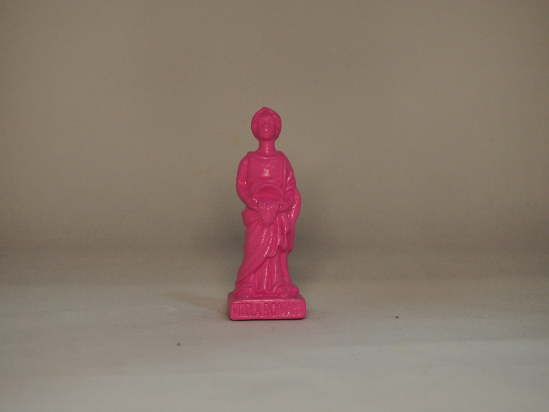 Estatueta pequena rosa de plástico com figura humana em pé