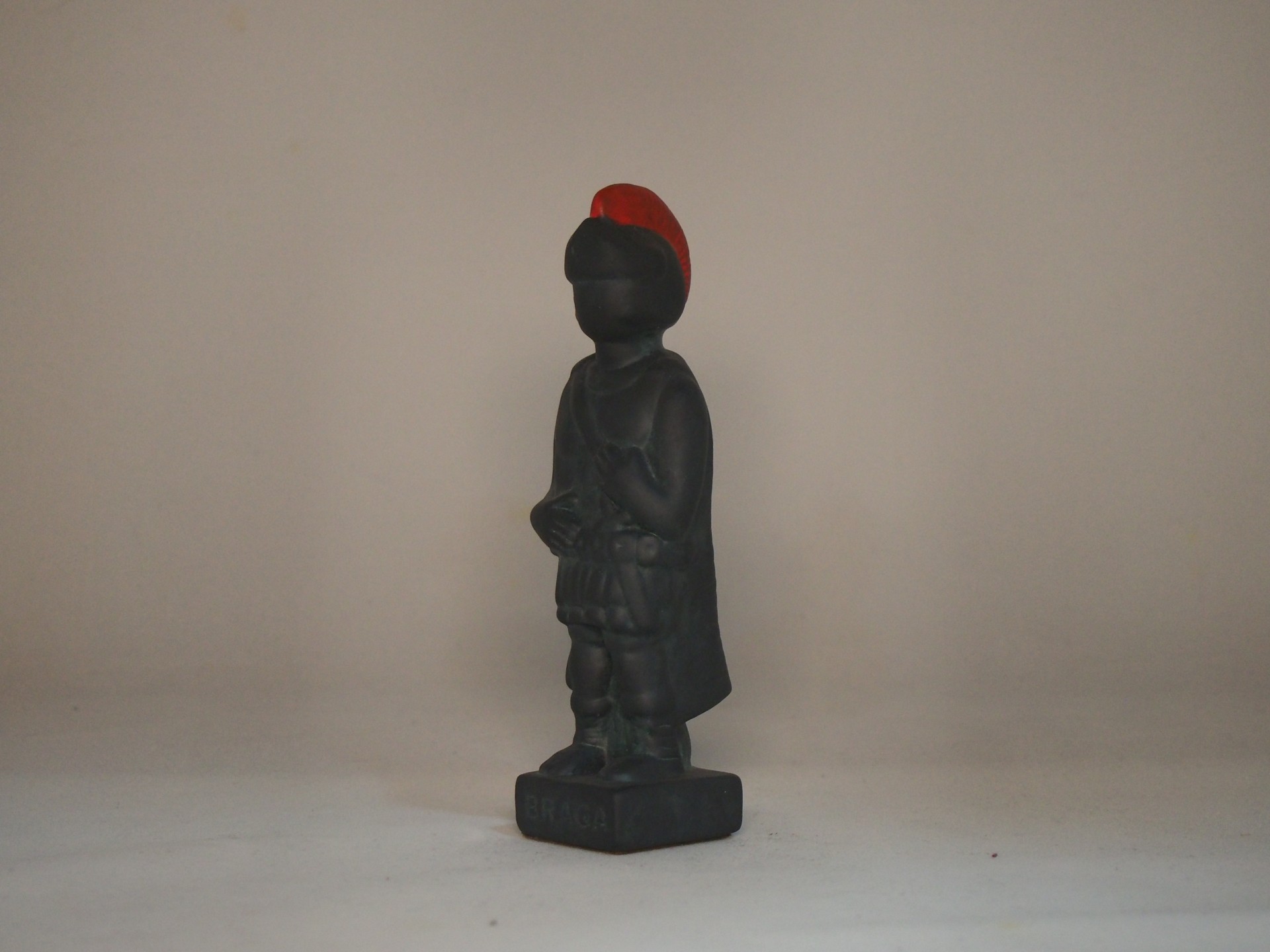 Estátua decorativa de soldado preto com capacete vermelho