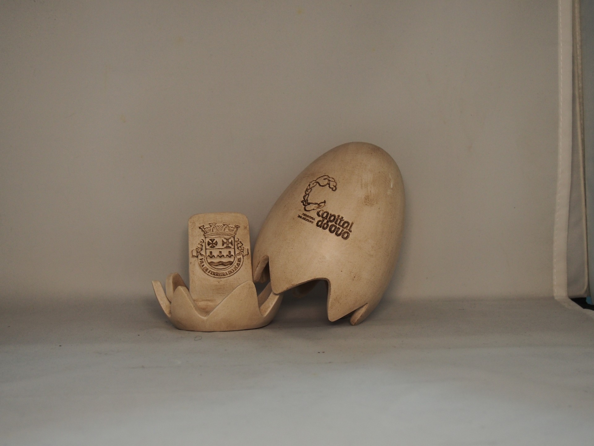 Conjunto de cerâmicas bege claro com gravações, sobre superfície cinza