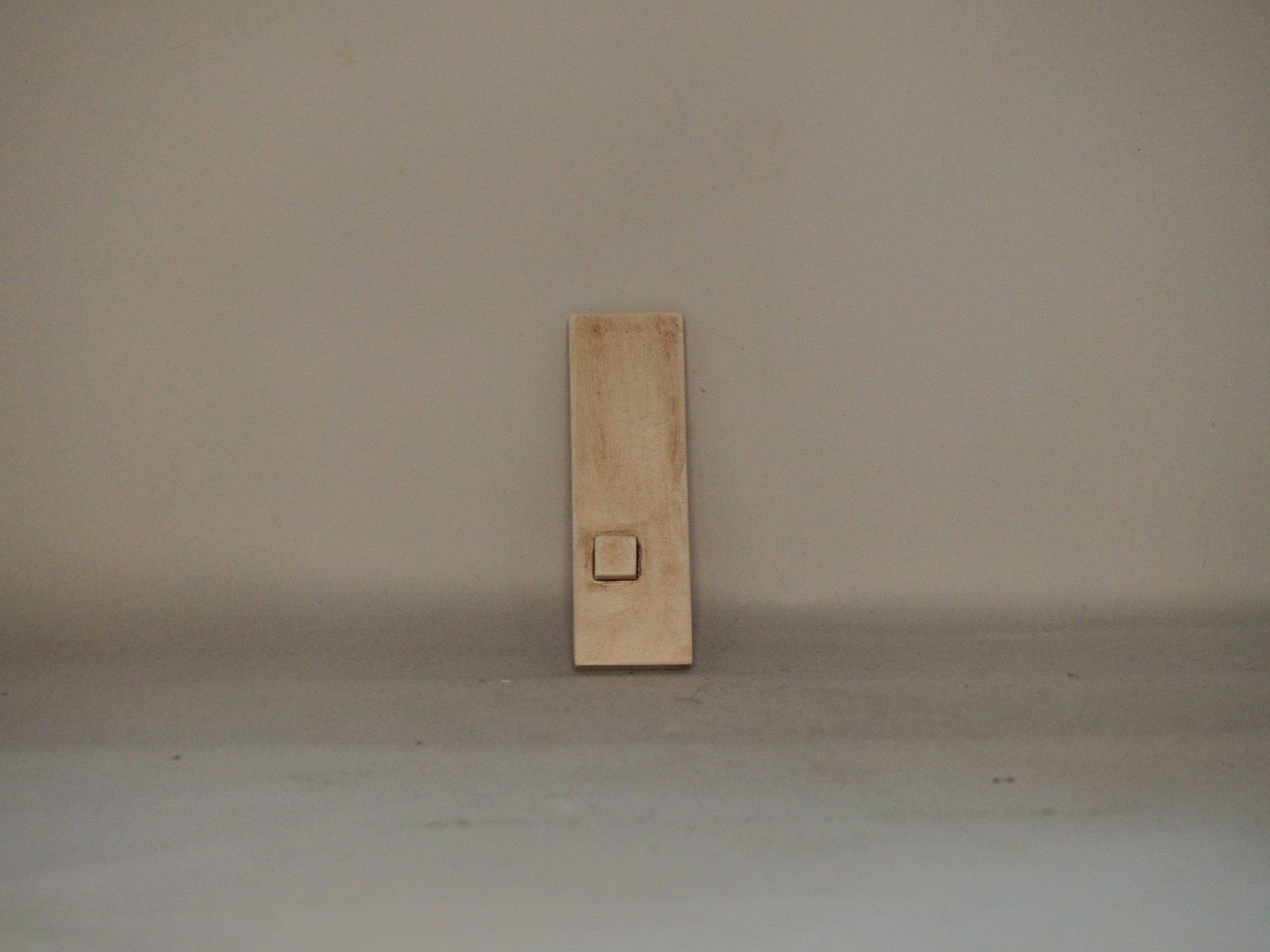 Campainha retangular bege com botão quadrado