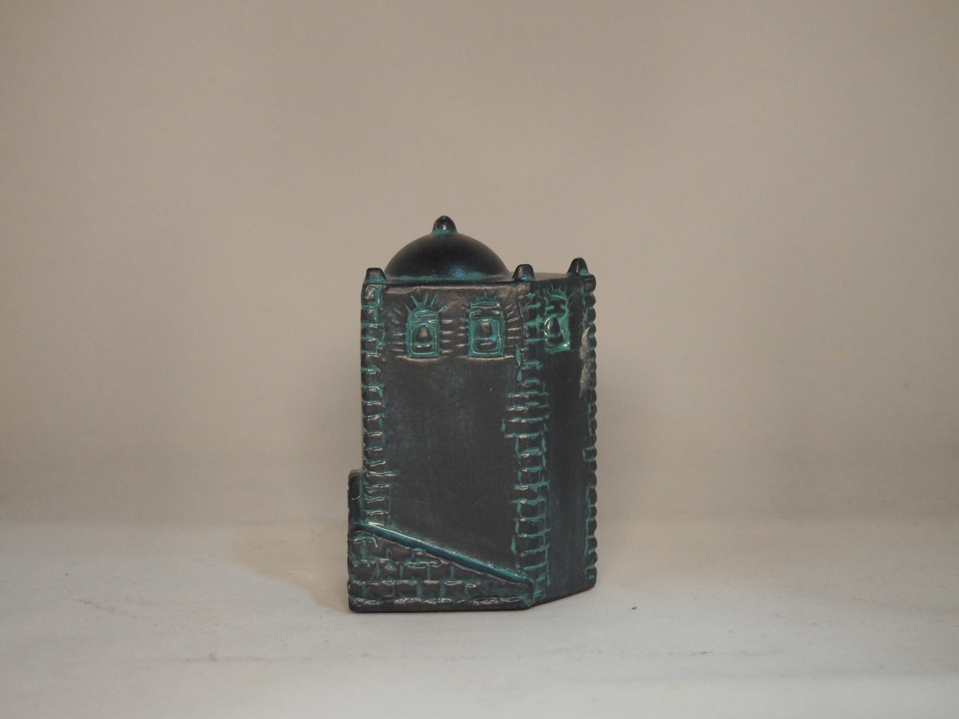 estatueta decorativa de cerâmica preta com detalhes verdes, forma arquitetónica