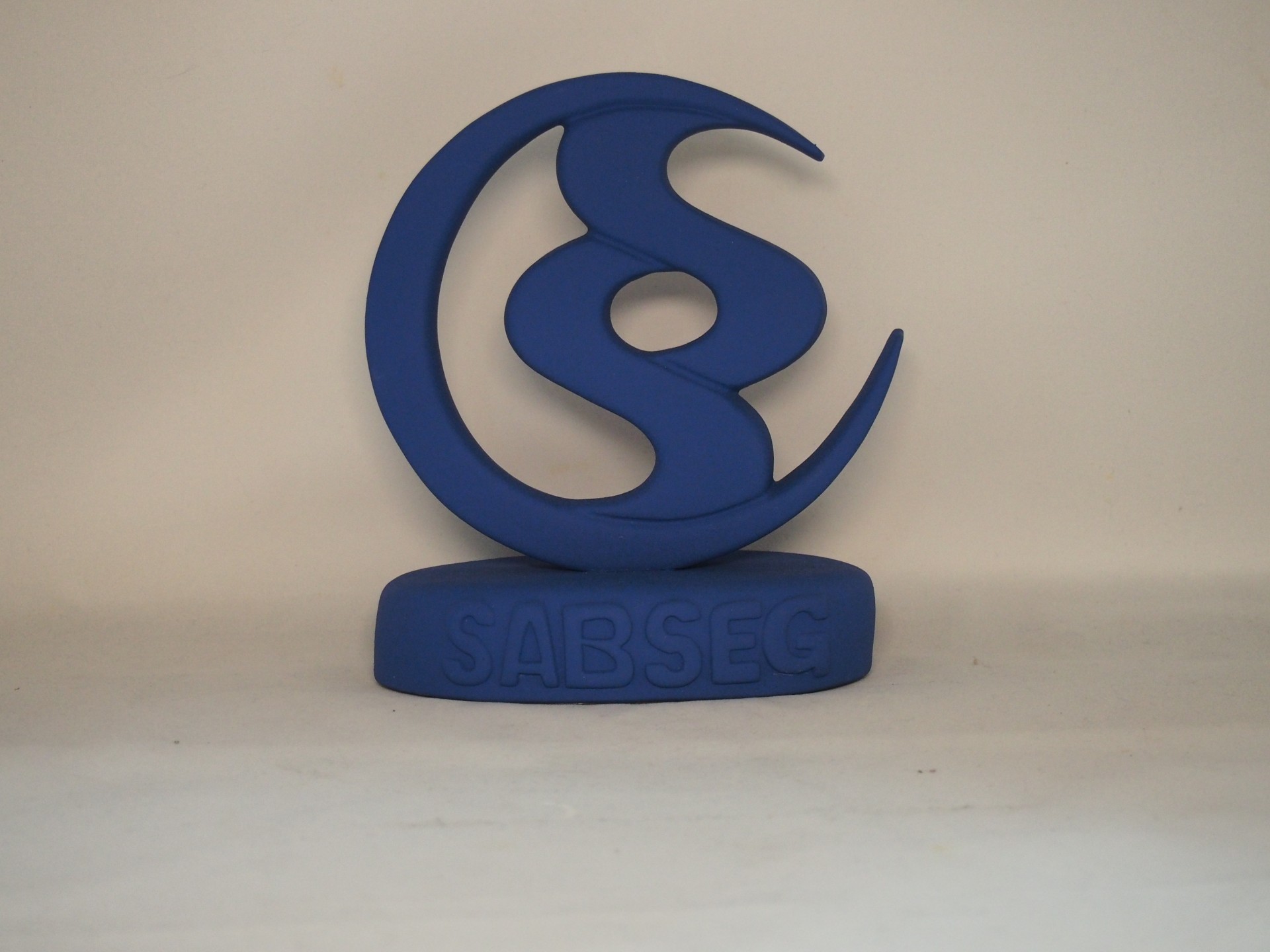 Escultura azul abstrata com base e texto SABSEG