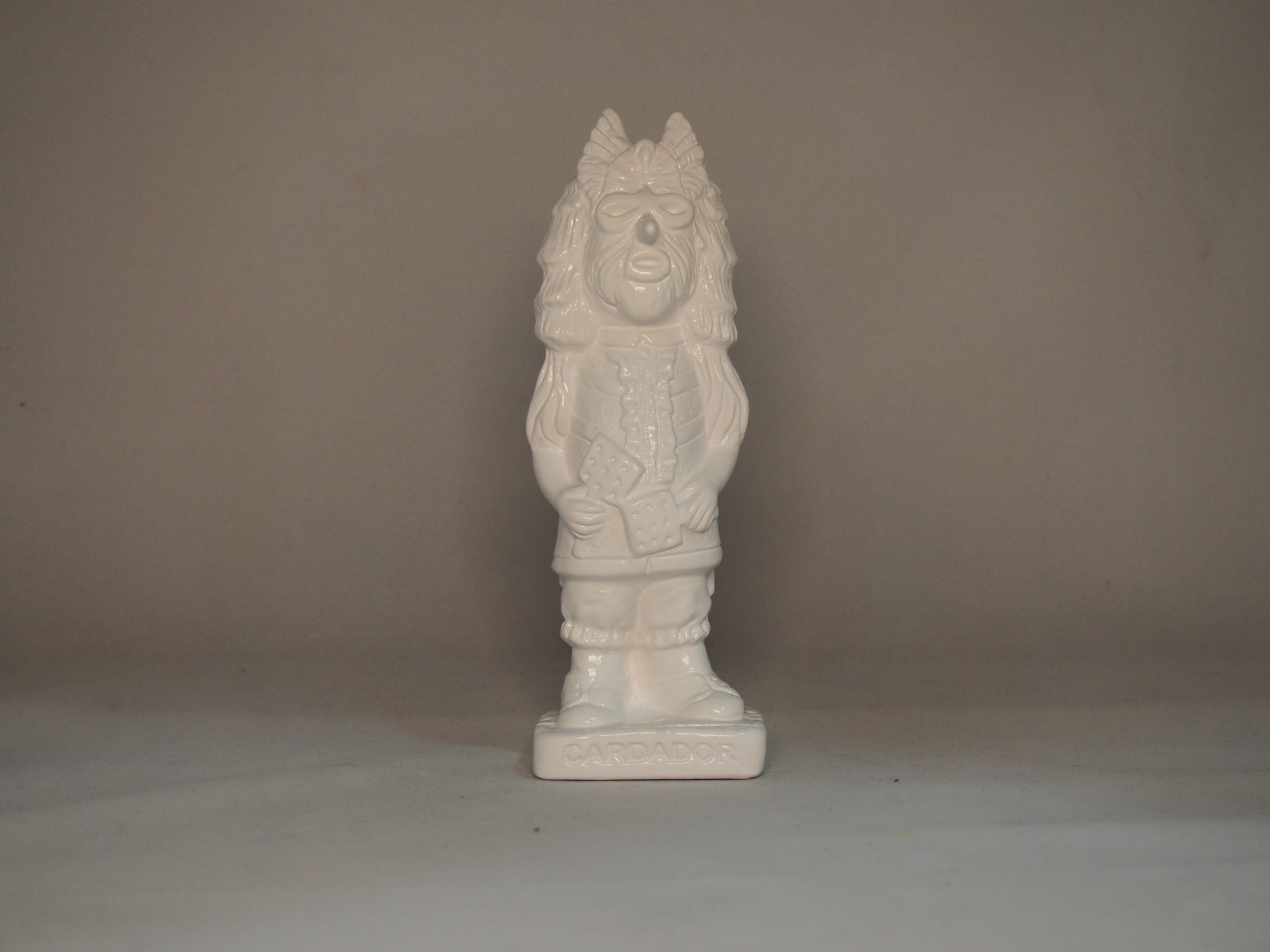 Estatueta branca de figura humana sobre base retangular