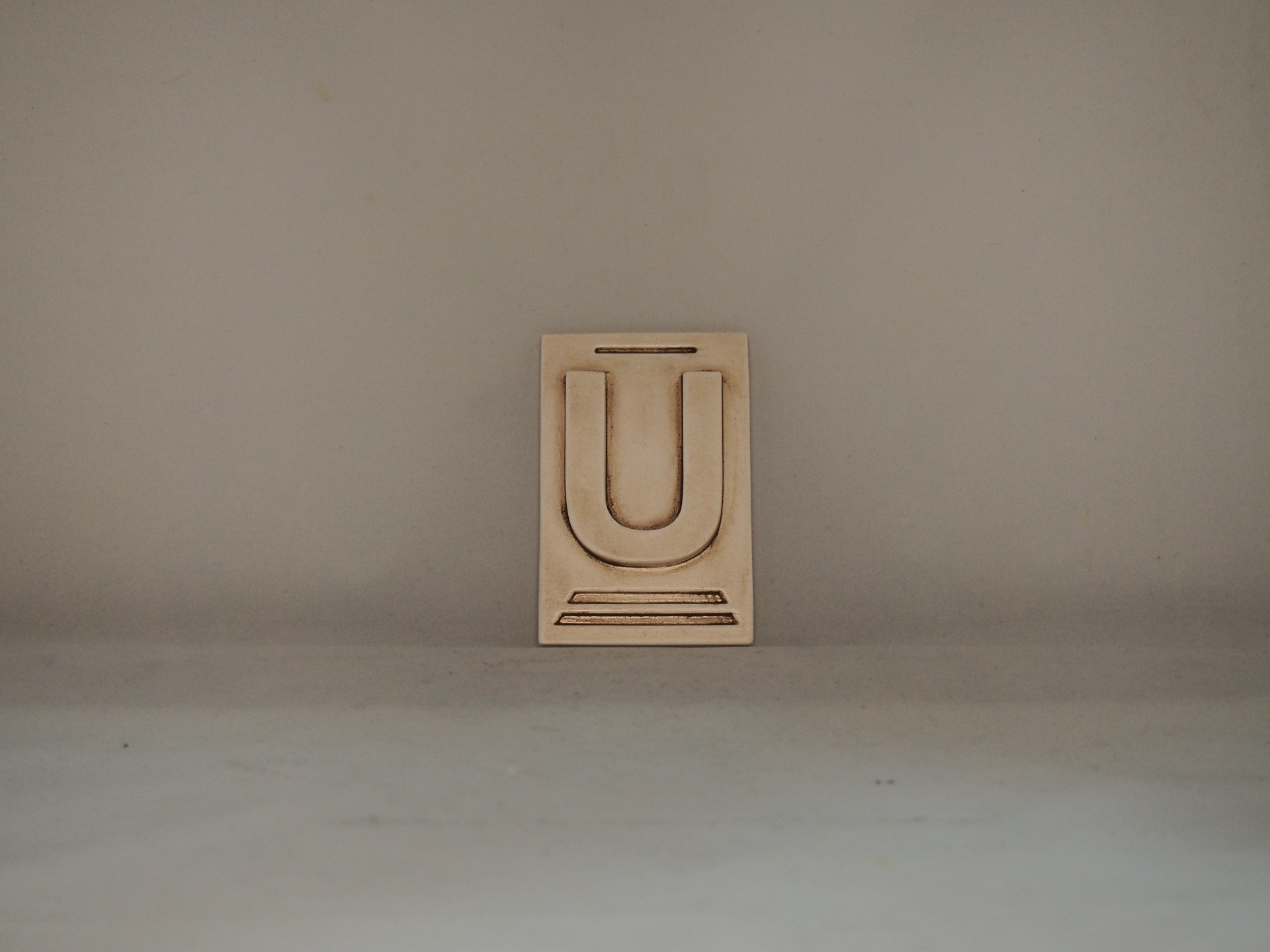 Bloco de tipografia em madeira com a letra U em relevo