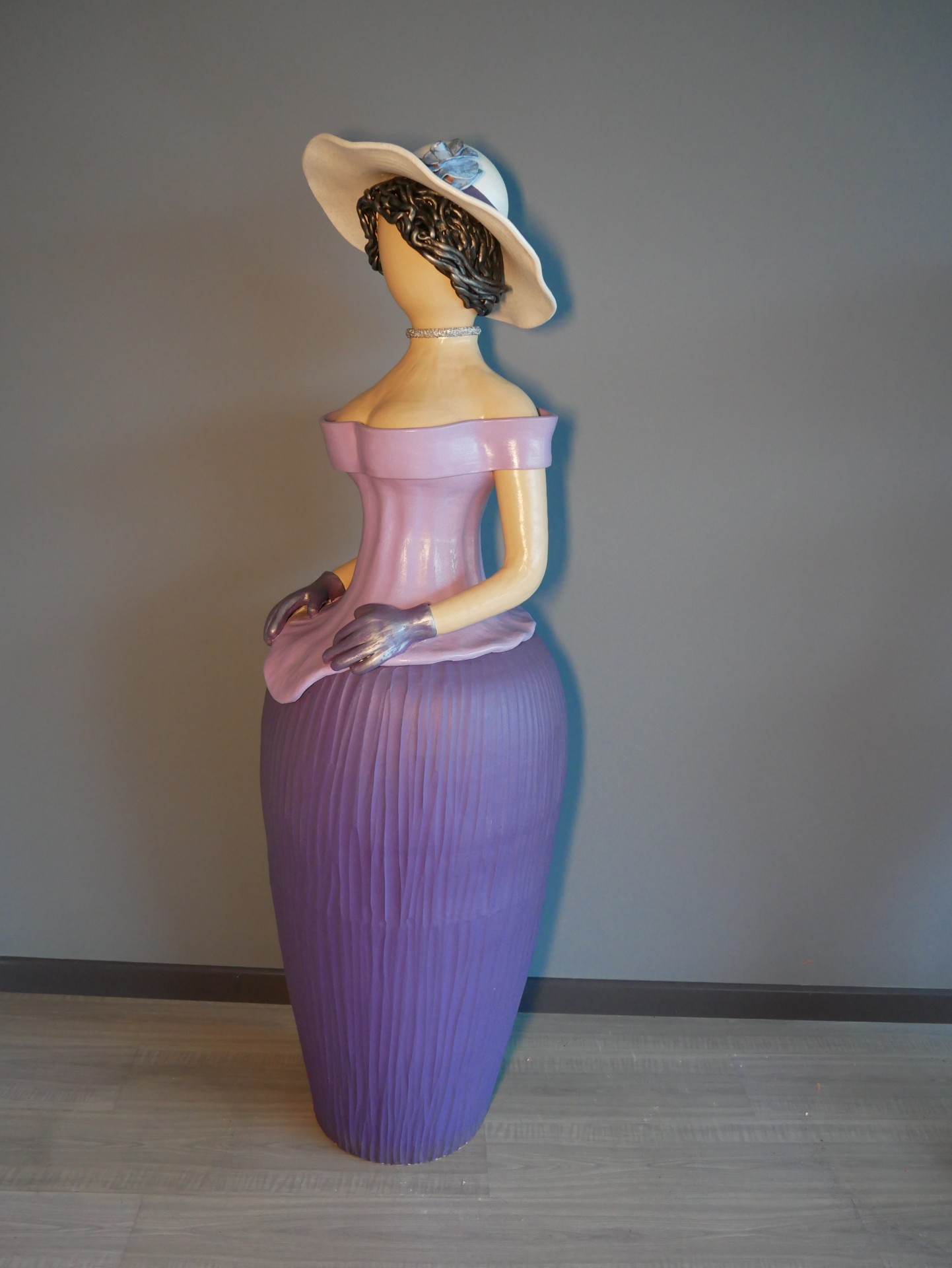 Estátua decorativa de mulher com vestido roxo e chapéu creme