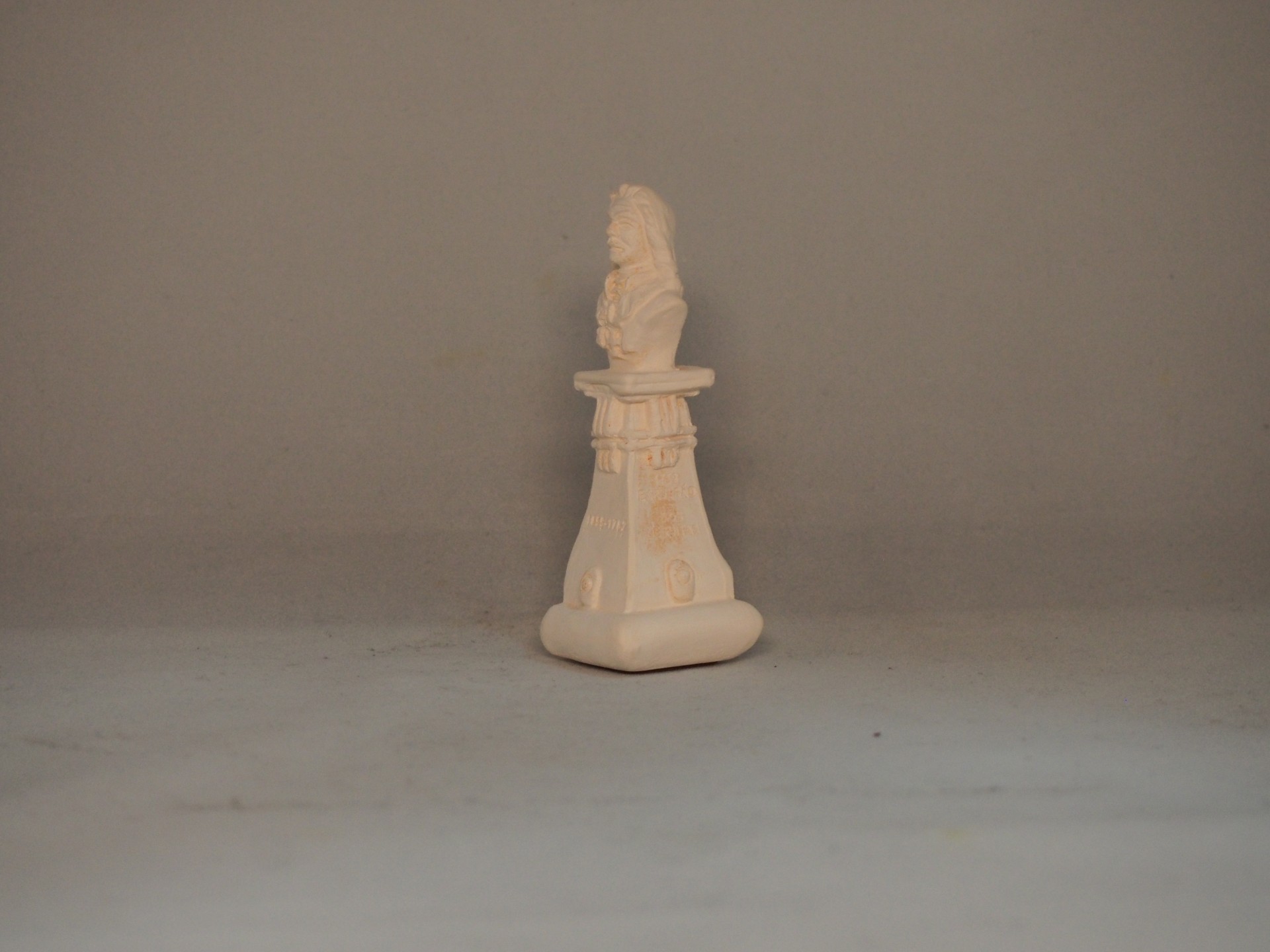 Estátua pequena decorativa beige em pedestal