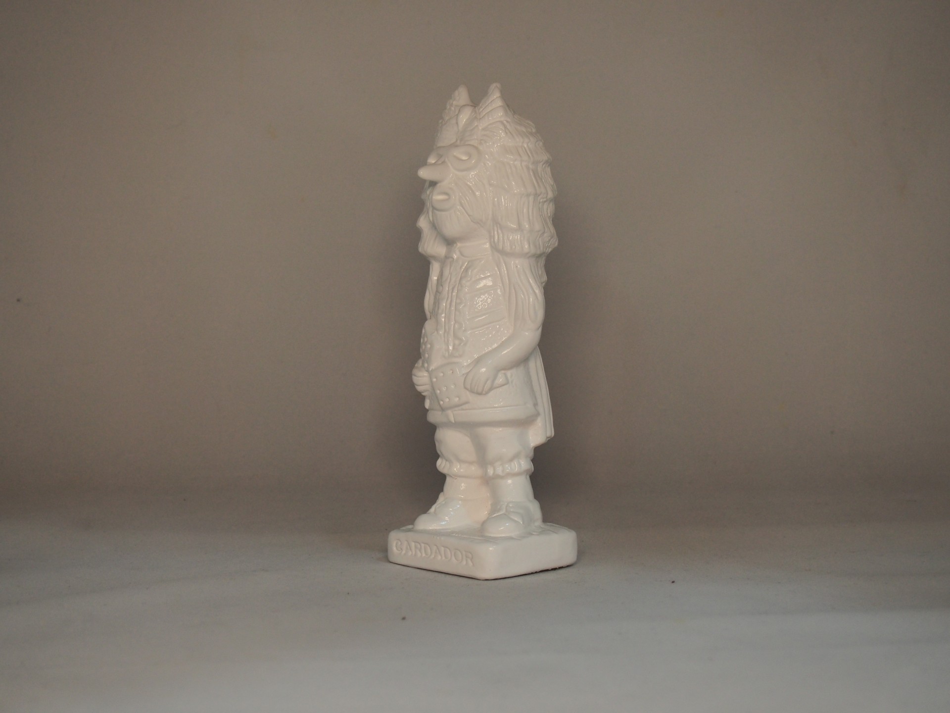 Estatueta branca em cerâmica com base quadrada e texto WIDDER